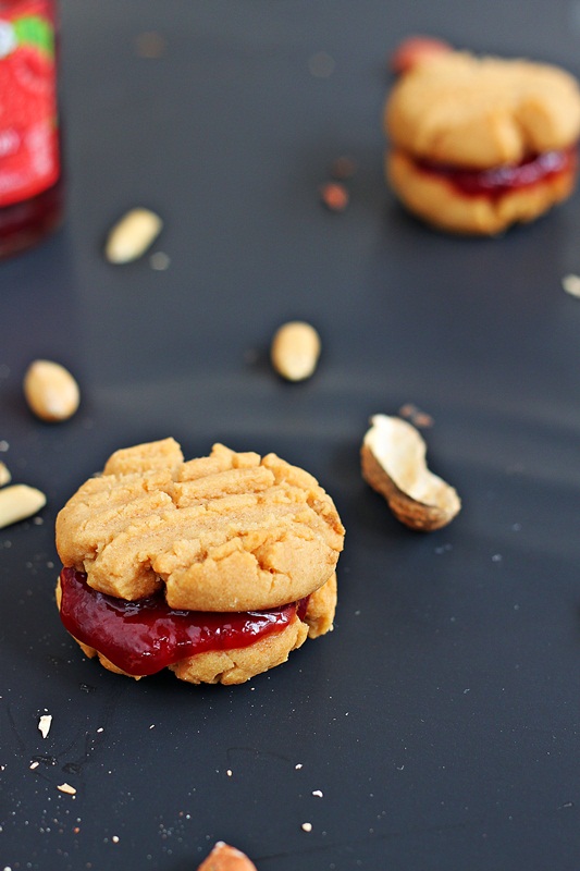 Soft melt-in-your-mouth Peanut Butter cookies sandwiched with berry jelly - Classic peanut butter jelly just got a make-over. Recipe from Roxanashomebaking.com