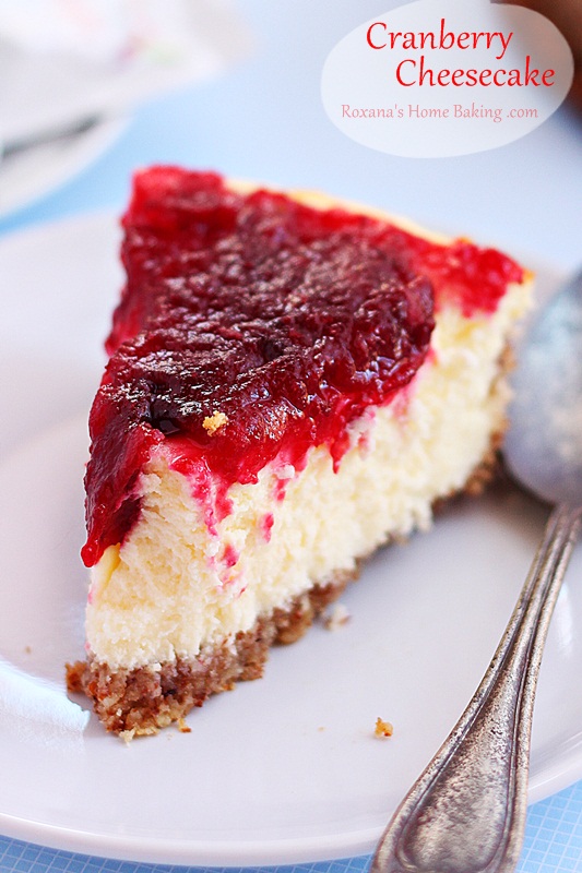 A creamy velvety cheesecake topped with cranberry sauce. Recipe from Roxanashomebaking.com