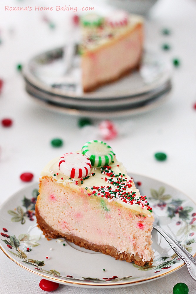 Velvety ricotta cheesecake mixed with crushed peppermint candy and topped with a layer of white chocolate ganache, Christmas candy and sprinkles.