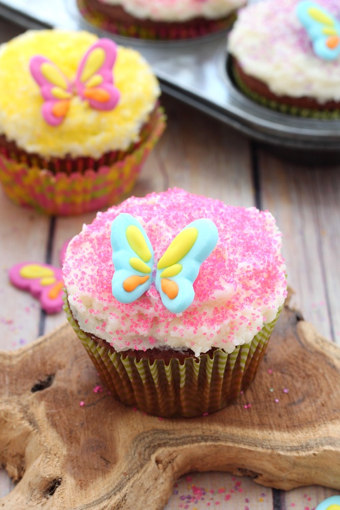 Nutty chocolate cupcakes with a creamy buttercream frosting and decorated with colored sugar, these chocolate almond cupcakes will be a hit with the little ones
