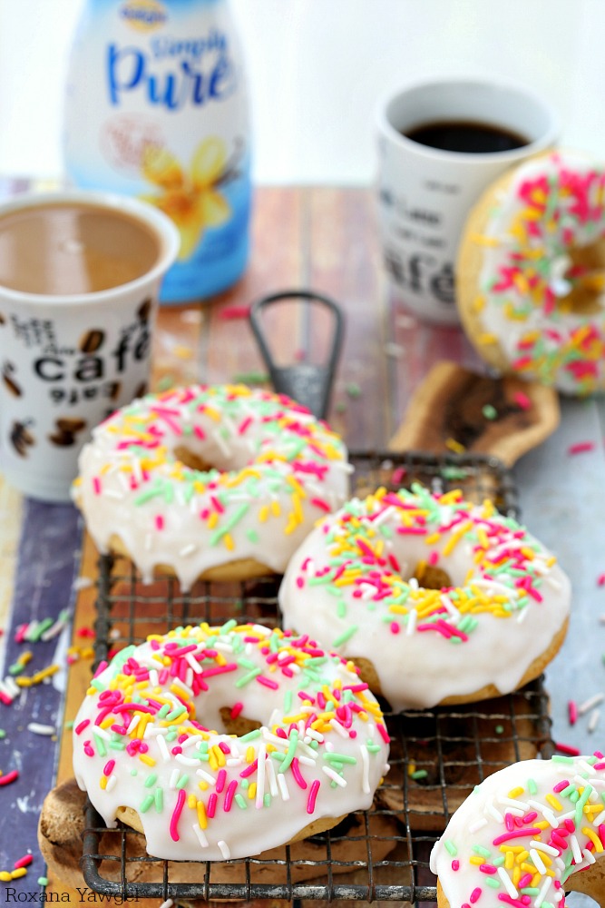 Soft and delicious baked donuts dipped in a thick vanilla glaze and topped with sprinkles, these glazed vanilla donuts are sure to brighten up your day! 