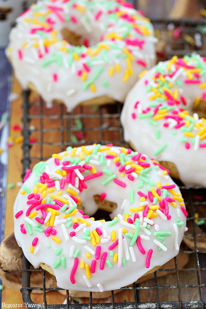 Soft and delicious baked donuts dipped in a thick vanilla glaze and topped with sprinkles, these glazed vanilla donuts are sure to brighten up your day! 