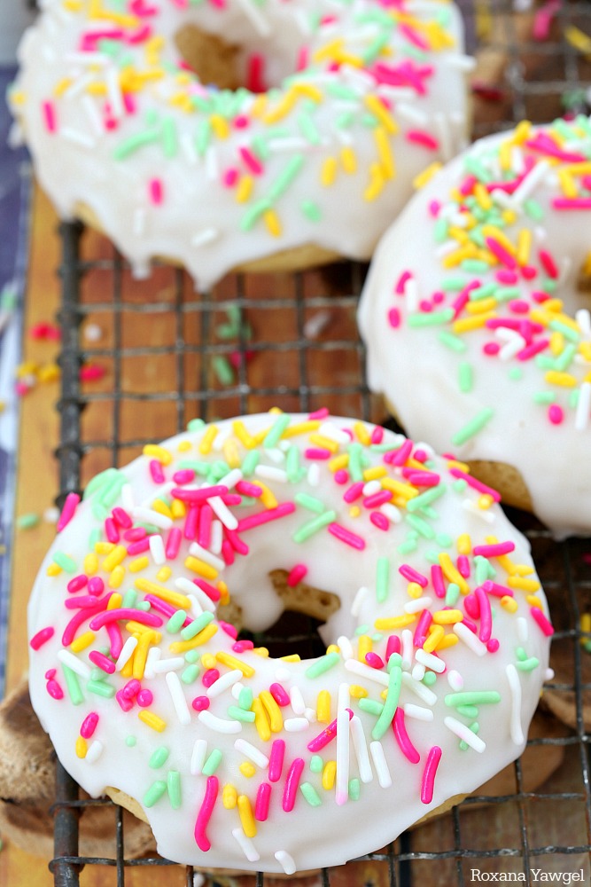 Soft and delicious baked donuts dipped in a thick vanilla glaze and topped with sprinkles, these glazed vanilla donuts are sure to brighten up your day! 
